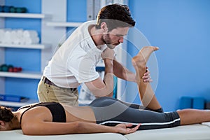 Male physiotherapist giving hip massage to female patient