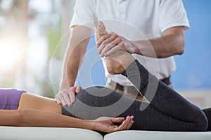 Male physiotherapist giving knee massage to female patient