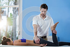 Male physiotherapist giving knee massage to female patient
