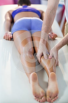 Male physiotherapist giving knee massage to female patient