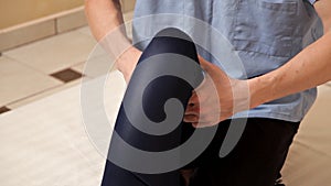 Male physiotherapist massaging the leg of a patient in the physiotherapy room. Therapeutic massage