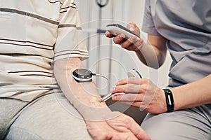 Male physiotherapist measuring muscle activity with testing unit