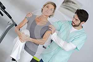 male physiotherapist working with mature female patient with knee injury