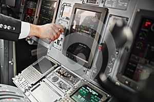 Male pilot turn button on passenger airplane jet