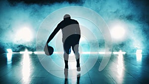 Male player is dribbling a basketball in dark