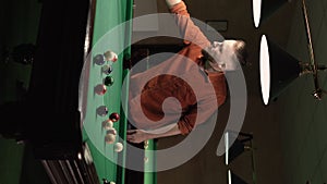 Male player placing colorful pyramid of billiard balls in billiard triangle on green pool table