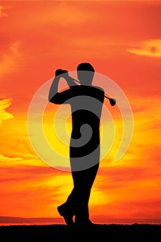 Male playing golf at dawn silhouetted with copy space silhouetted with copy space
