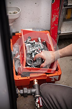 male plumber with a box full of pipes and sockets and connections