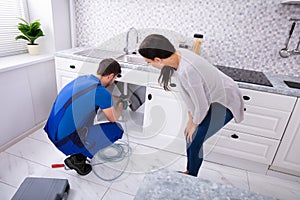 Male Plumber Cleaning Clogged Sink Pipe With Drained Cable