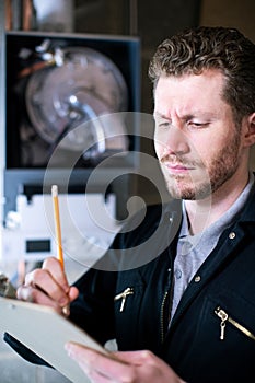 Male Plumber With Clipboard Installing Central Heating Boiler