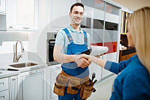 Male plumber and female customer in the kitchen