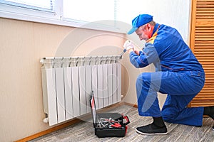 Male plumber fixes a leak. The adjustable wrench tighten the nut clamps seals, isolates