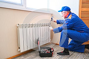 Male plumber fixes a leak. The adjustable wrench tighten the nut clamps seals, isolates