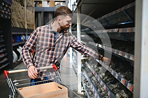 male plumber in a hardware store chooses the sewer pipes, the concept of plumbing work in the house