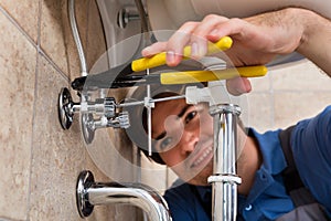 Male Plumber Installing Kitchen Sink