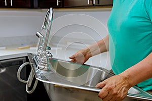 Male plumber prepared to instal kitchen sink photo