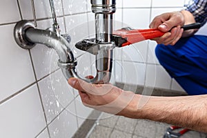 Plumber Repairing Sink Pipe Leakage photo