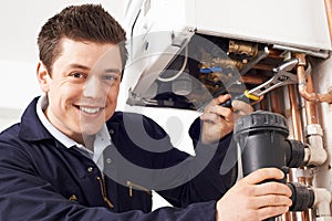 Male Plumber Working On Central Heating Boiler photo
