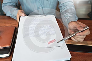 Male point to signing business document for putting signature, fountain pen and approved stamped on a document, certificate