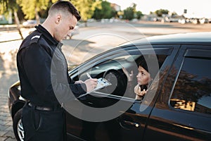 Male police officers check vehicle on the road