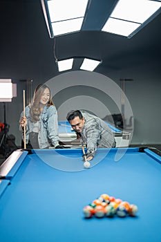 male pool player with glove poking the white ball