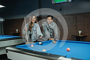 male pool player paying attention on the female pool player