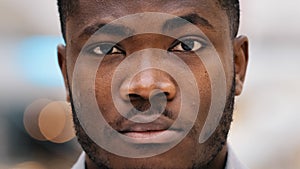 Male portrait of close-up serious african american man looking in camera confident young businessman freelancer stands