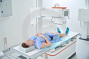 Patient undergoing knee x-ray with digital radiographic equipment photo