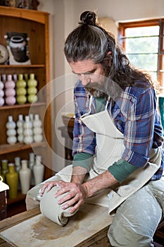 Male potter molding clay