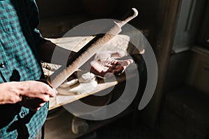 Male potter use rollong pin for clay. Man in workshop