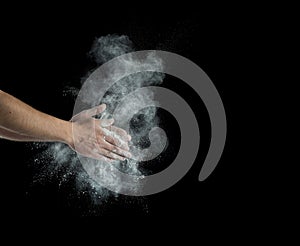 Male powerlifter hand in talc splash preparing to work hard photo