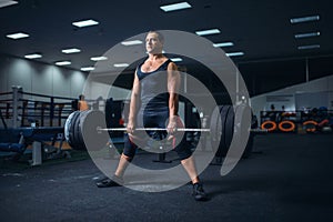 Male powerlifter preparing deadlift barbell in gym
