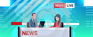 Male presenter interviewing woman in television studio tv live news show video camera shooting crew broadcasting concept
