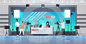 Male presenter interviewing woman in television studio tv live news show video camera shooting crew broadcasting concept