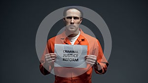 Male prisoner holding Criminal justice reform sign, human rights protection