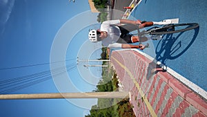 Male pro cyclist riding bike out of saddle along cycle lane path at sunny morning. Vertical video. Athlete training on bicycle, pr