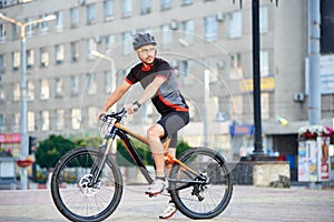 Male cyclist training on bike after hard working day