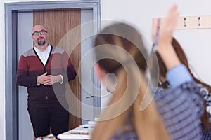 Male professor of architecture explain lesson to multiethnic students and interact with them in the modern classroom.Helping a