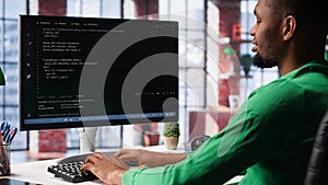 Male programmer types code on computer and running script