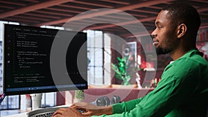 Male programmer types code on computer and running script