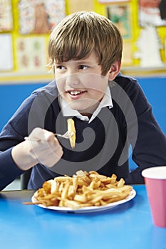 Male Pupil Eating Unhealthy School Lunch