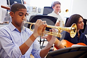 Male Pupil Playing Trumpet In High School Orchestra photo