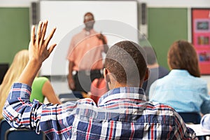 Male Pupil Raising Hand In Class photo