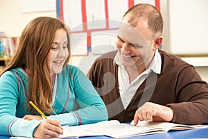 Male Pupil Studying in classroom with teacher