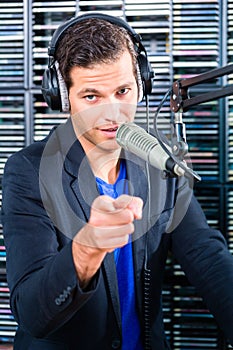 Male radio presenter in radio station on air