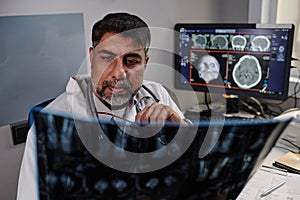 Male Radiographer Looking At X-ray Image photo