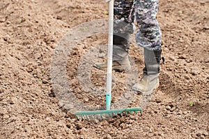 Male With Rake On Field In Spring Close Up