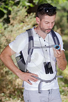 Male rambler looking at compass