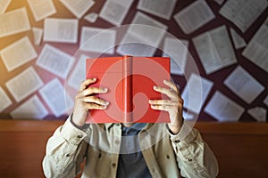 Male reader reading a red book in the bookstore.