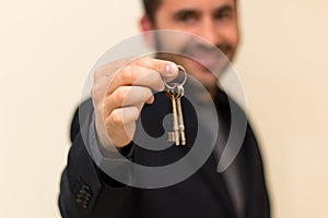 Male real estate agent smiling while handing over keys